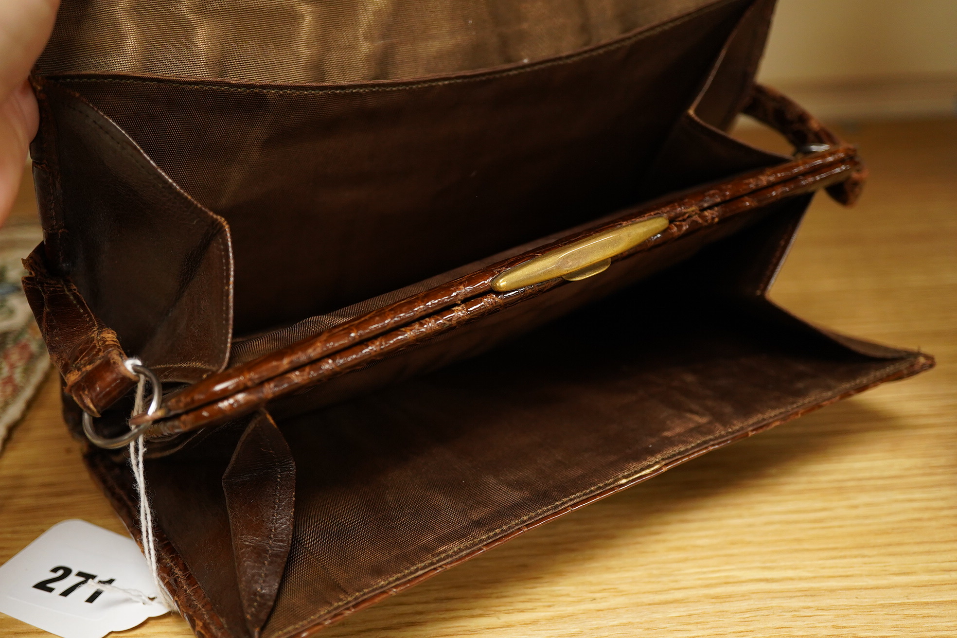 A stylish 1930's ladies 9ct gold mounted brown crocodile handbag, fitted with small wallet and mirror, 21.5cm wide x 15cm high. Condition - the corners to base, top and handle have wear, the silk lining has a small split